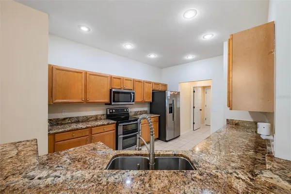 a kitchen that has a lot of cabinets in it and stainless steel appliances