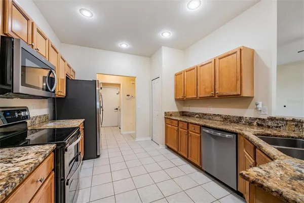 a kitchen with stainless steel appliances granite countertop a stove a sink dishwasher and a refrigerator