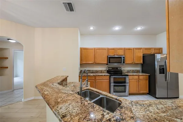 a kitchen with stainless steel appliances granite countertop a sink stove and refrigerator