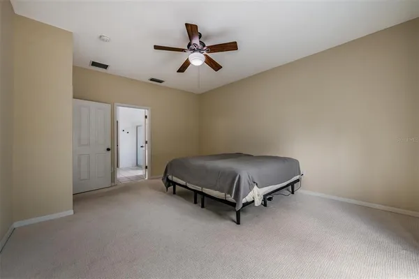 a room with a bed and a ceiling fan