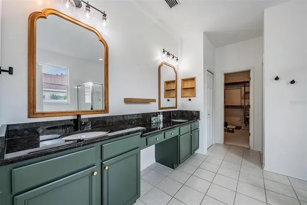 a spacious bathroom with a granite countertop sink and mirror