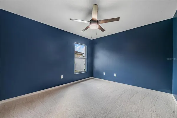 en empty room with windows and fan