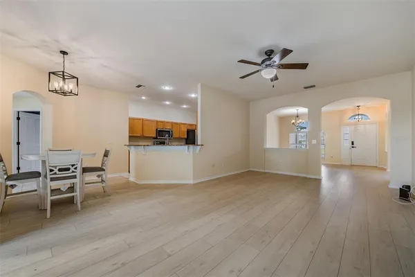 a view of a livingroom with furniture wooden floor and a ceiling fan