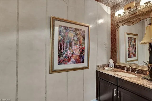 a bathroom with a painting on the wall and a double vanity sink