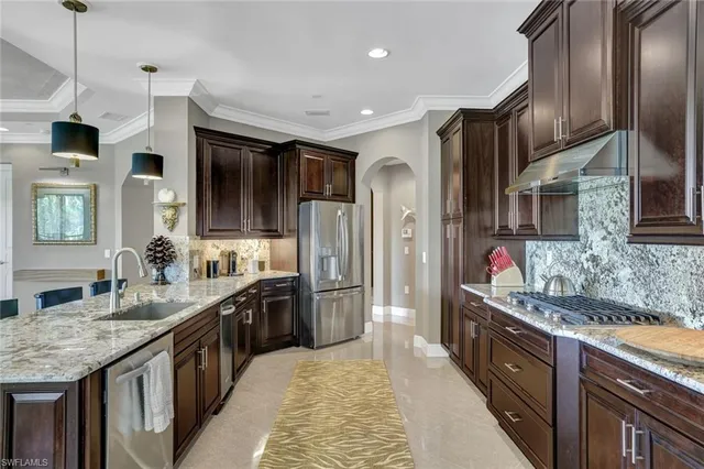 a spacious kitchen with stainless steel appliances granite countertop a sink stove and refrigerator
