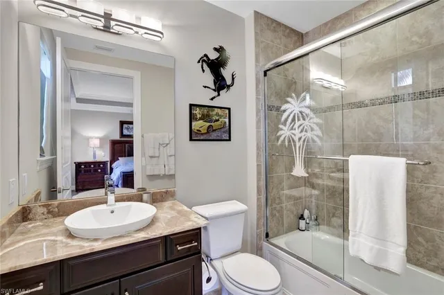 a bathroom with a granite countertop sink toilet a mirror a bathtub and shower