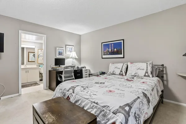 a large bedroom with a bed and wooden floor