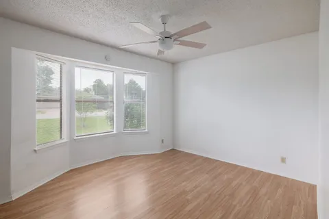 a view of a room with wooden floor and window