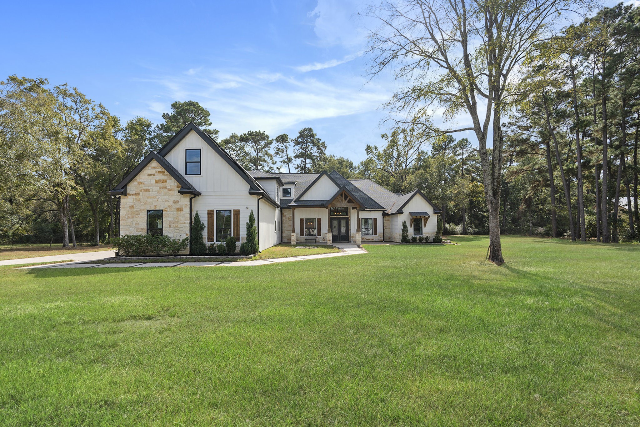a view of a house with a big yard and large trees