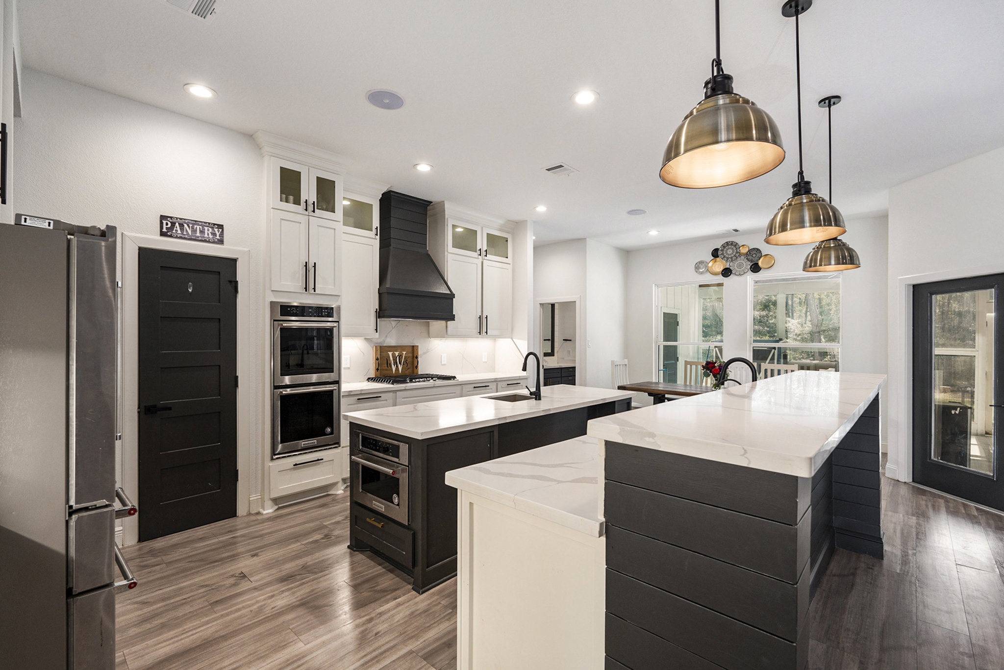 11211 Leonidas Horton Road Conroe, TX 77304 - Photo 11 of 47 Chef's dream kitchen with dual ovens, a prep sink, gorgeous two-toned cabinets, breakfast bar seating, and a walk-in pantry.