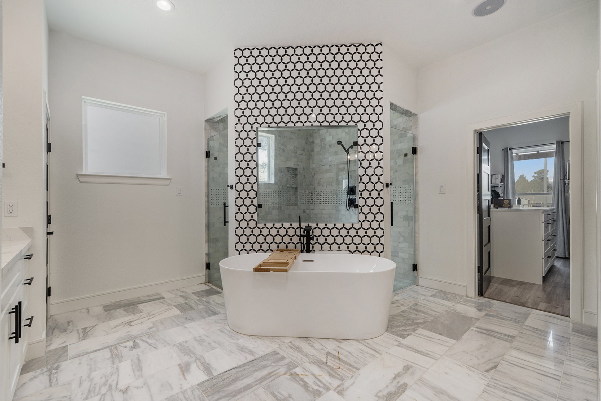 11211 Leonidas Horton Road Conroe, TX 77304 - Photo 15 of 47 Lavish primary bathroom with stunning flooring, a soaking tub, a glass-standing shower, dual vanities, and a huge walk-in closet.