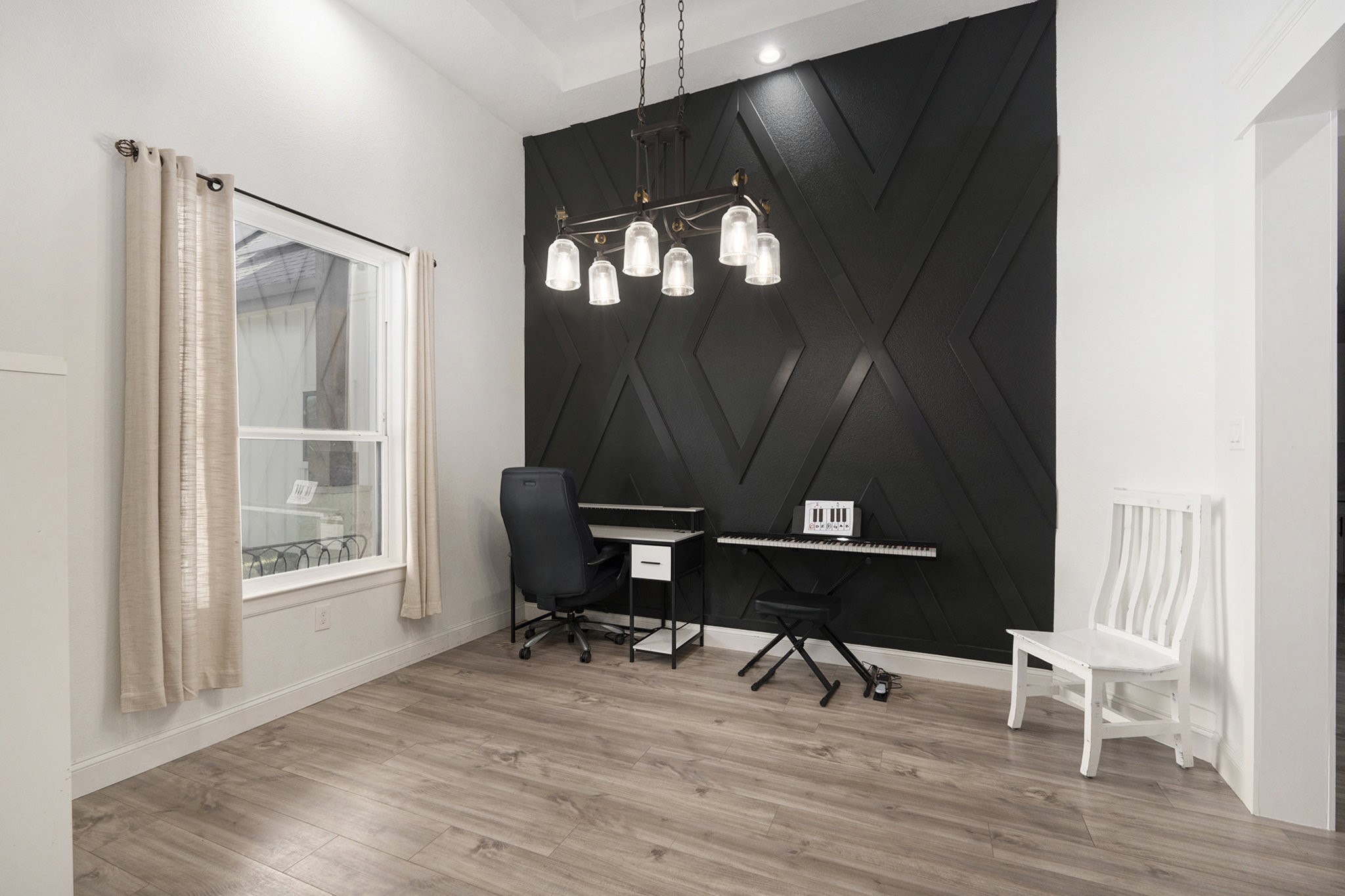 11211 Leonidas Horton Road Conroe, TX 77304 - Photo 7 of 47 Versatile flex room featuring a striking black accent wall, elegant lighting, and ample natural light — perfect for a an additional home office or formal dining room.