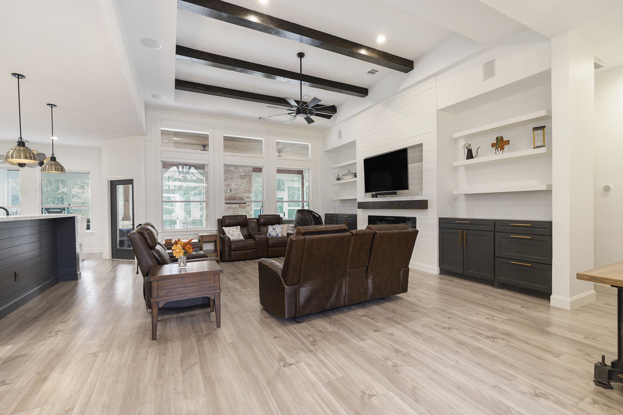 11211 Leonidas Horton Road Conroe, TX 77304 - Photo 9 of 47 Remarkable living room showcasing soaring ceilings with stunning wood beams, custom built-ins, and serene views of the backyard.