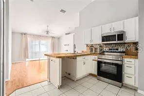 a kitchen with granite countertop a stove sink and microwave