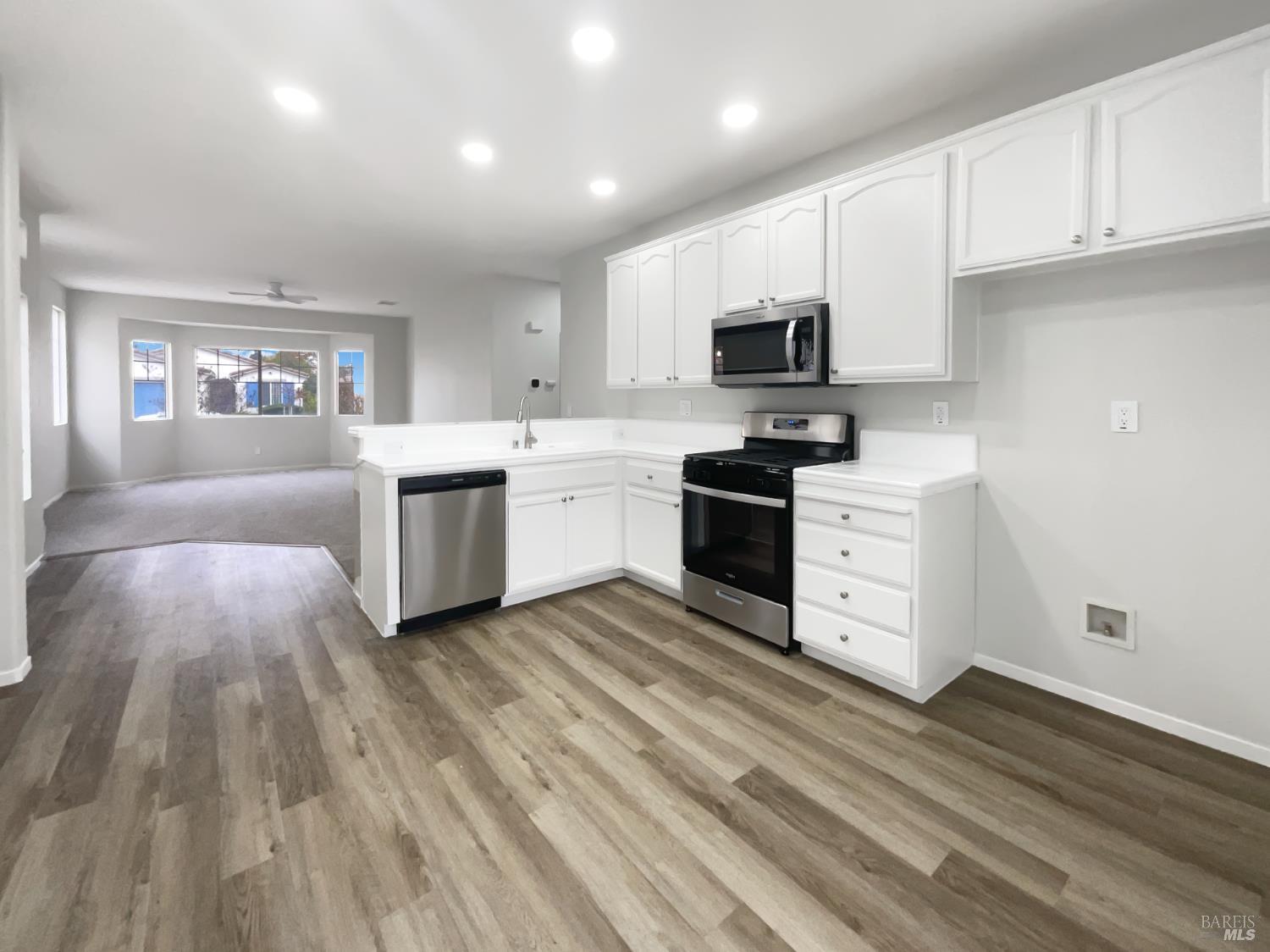 971 Bridgeport Way Rio Vista, CA 94571 - Photo 8 of 39 a kitchen with stainless steel appliances a stove top oven a sink dishwasher and a refrigerator with wooden floor