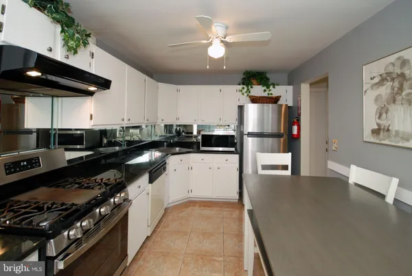 a kitchen with stainless steel appliances kitchen island a refrigerator and a stove top oven