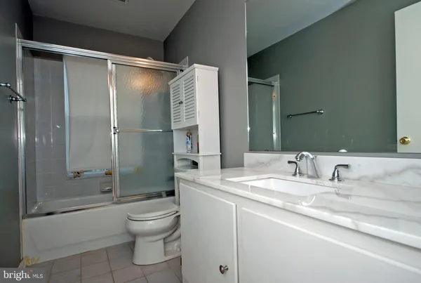 a bathroom with a shower sink vanity mirror and toilet