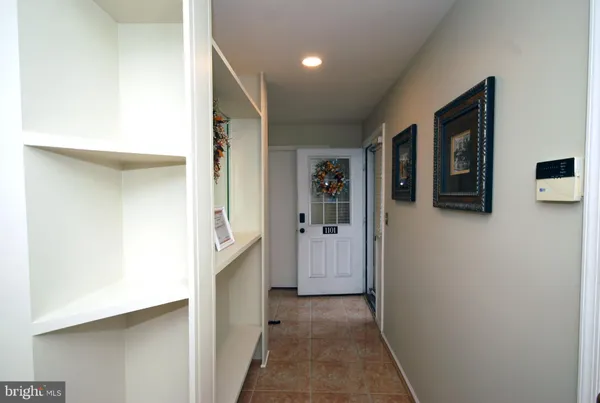 a view of a hallway with wooden shelves