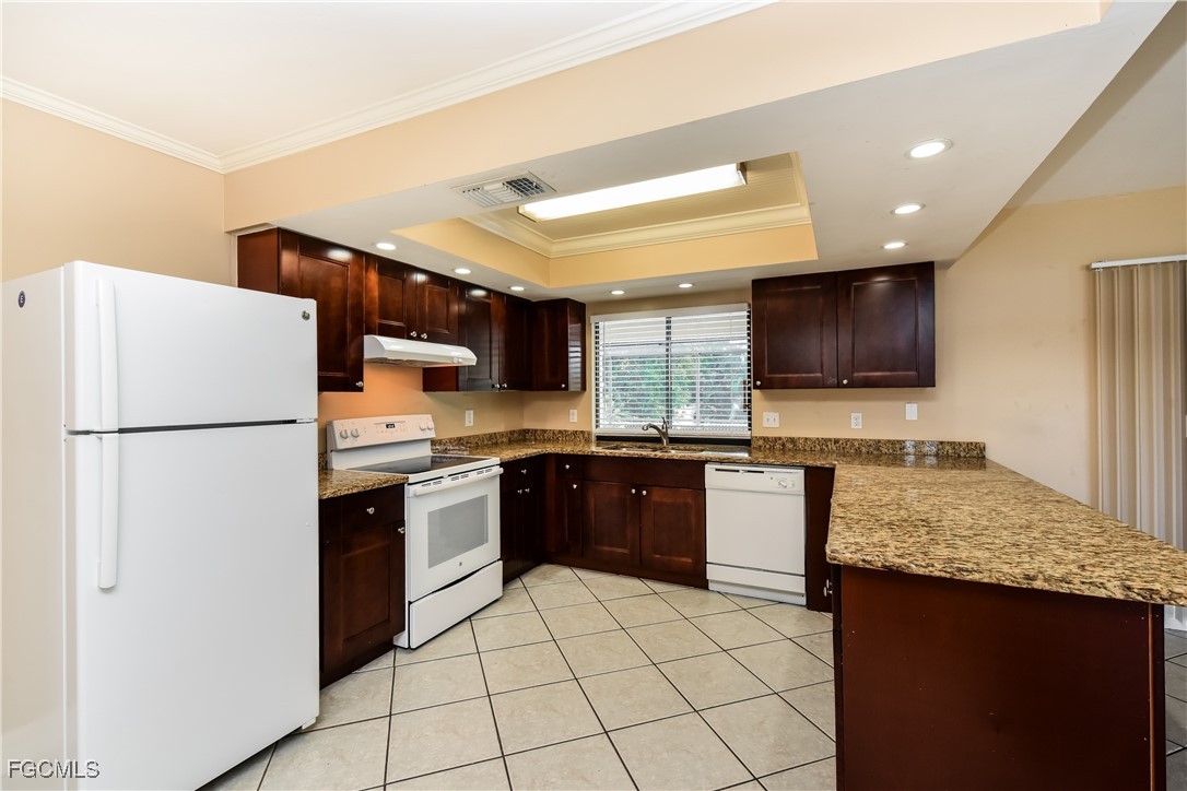 17365 Castile Road Fort Myers, FL 33967 - Photo 7 of 16 a kitchen with a refrigerator a microwave a sink and a counter top space