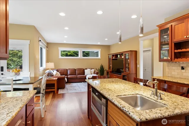 a living room with granite countertop couches a coffee table and flat screen tv