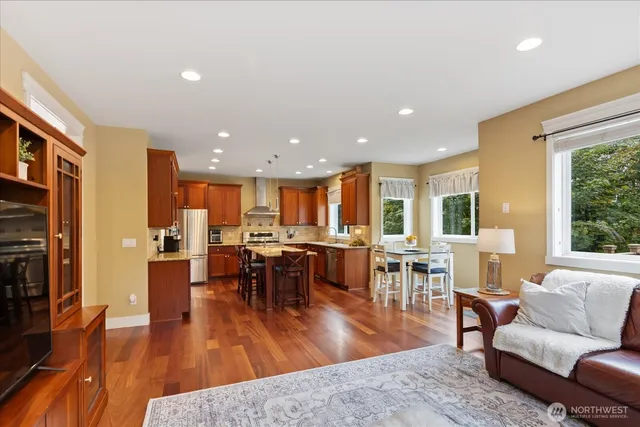a living room with furniture a wooden floor dining table and a large window