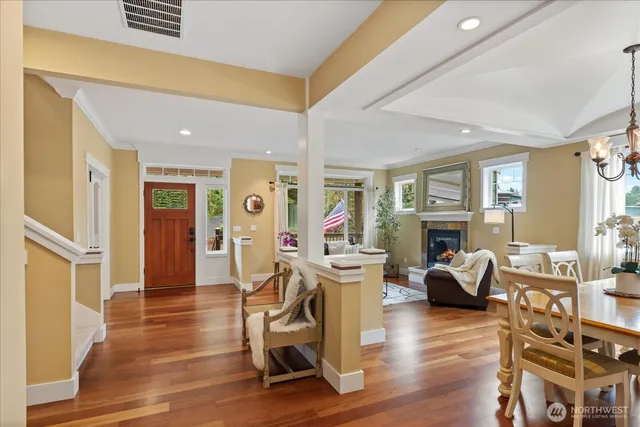 a view of a livingroom with furniture a rug wooden floor and windows