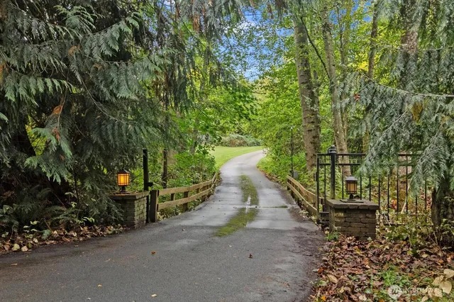 a pathway of a house with large trees