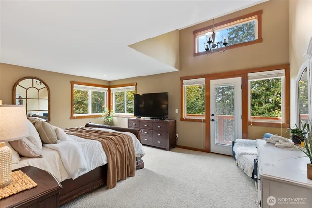 a bed room with a bed couch and a flat tv screen