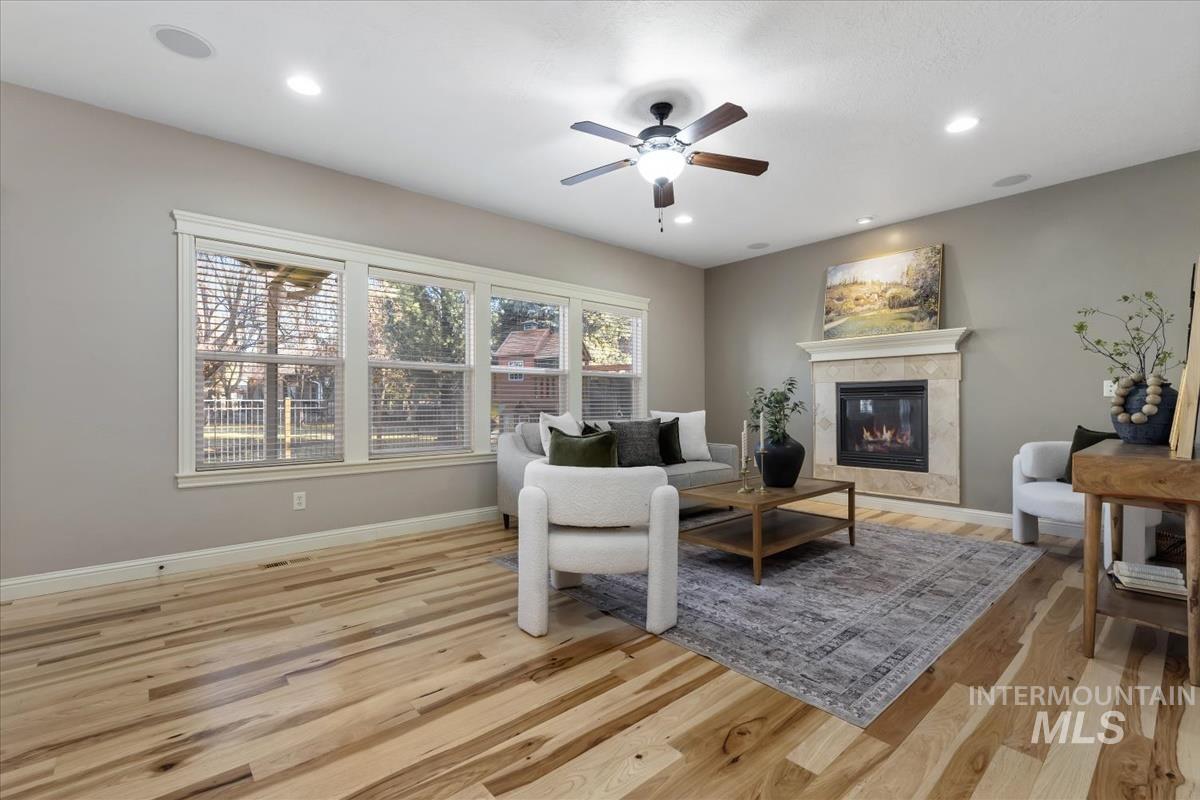 1082 East Azan Street Meridian, ID 83646 - Photo 15 of 47 Living area featuring light wood-type flooring, a tile fireplace, a ceiling fan, and recessed lighting