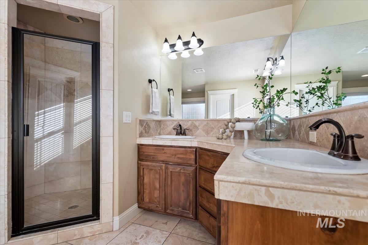 1082 East Azan Street Meridian, ID 83646 - Photo 28 of 47 Bathroom with double vanity, a shower stall, and light tile patterned floors