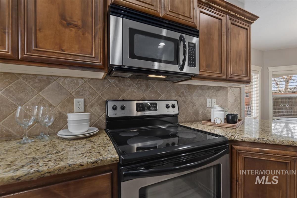 1082 East Azan Street Meridian, ID 83646 - Photo 10 of 47 Kitchen featuring stainless steel appliances, light stone countertops, and tasteful backsplash