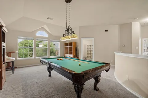 a room with pool table and windows
