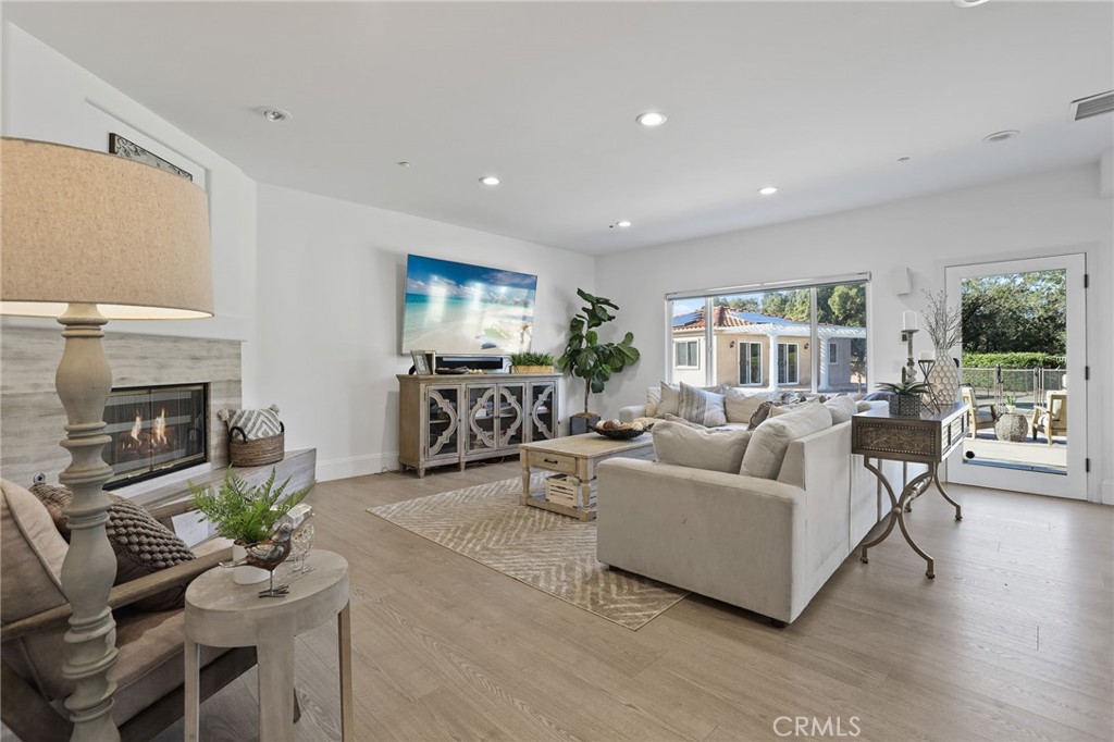 2 Olympic Way Coto de Caza, CA 92679 - Photo 15 of 75 a living room with furniture a fireplace a flat screen tv and a large window