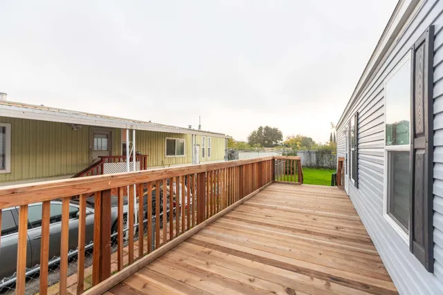 a view of a balcony with wooden floor and fence