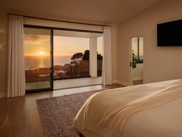 a bedroom with a large bed and a flat tv screen on dresser