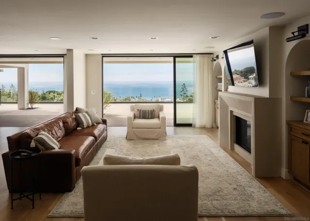 a living room with furniture large window and a fireplace