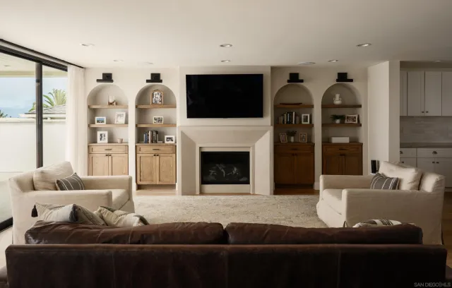 a living room with furniture a flat screen tv and a fireplace