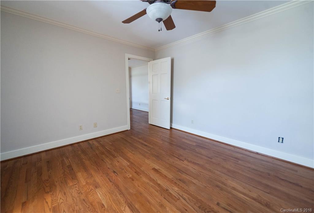 484 Pierce Road Landrum, SC 29356 - Photo 13 of 35 an empty room with wooden floor chandelier fan and windows