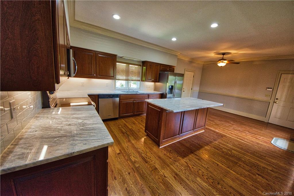 484 Pierce Road Landrum, SC 29356 - Photo 4 of 35 a large kitchen with stainless steel appliances a large counter top a stove and a wooden floors