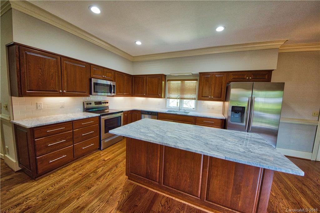 484 Pierce Road Landrum, SC 29356 - Photo 6 of 35 a kitchen with wooden floors and wooden cabinets