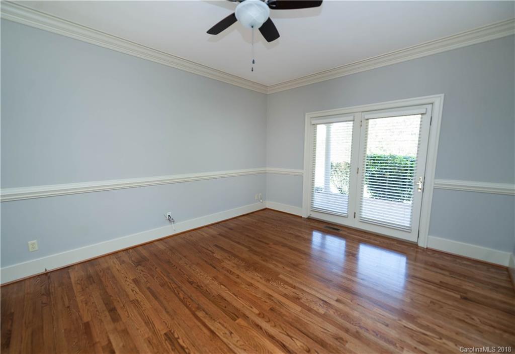 484 Pierce Road Landrum, SC 29356 - Photo 8 of 35 an empty room with wooden floor chandelier fan and windows