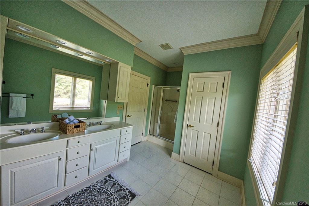484 Pierce Road Landrum, SC 29356 - Photo 9 of 35 a large bathroom with a double vanity sink a mirror and a shower