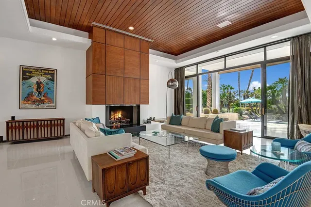 a living room with furniture a fireplace and a large window