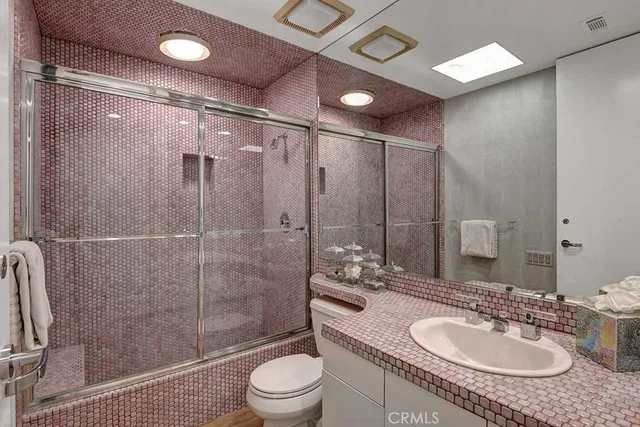 a bathroom with a sink granite toilet and shower