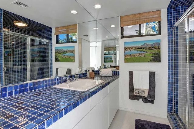 a bathroom with a granite countertop sink and a large mirror