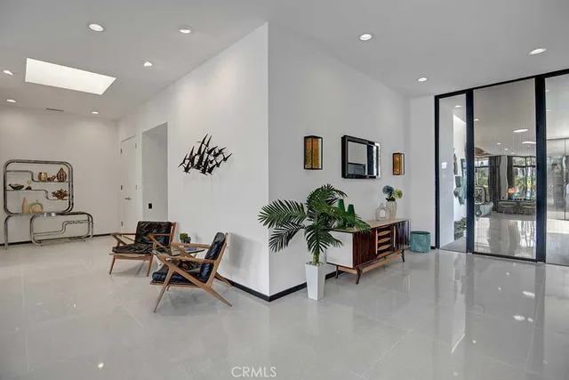 a living room with furniture and potted plants