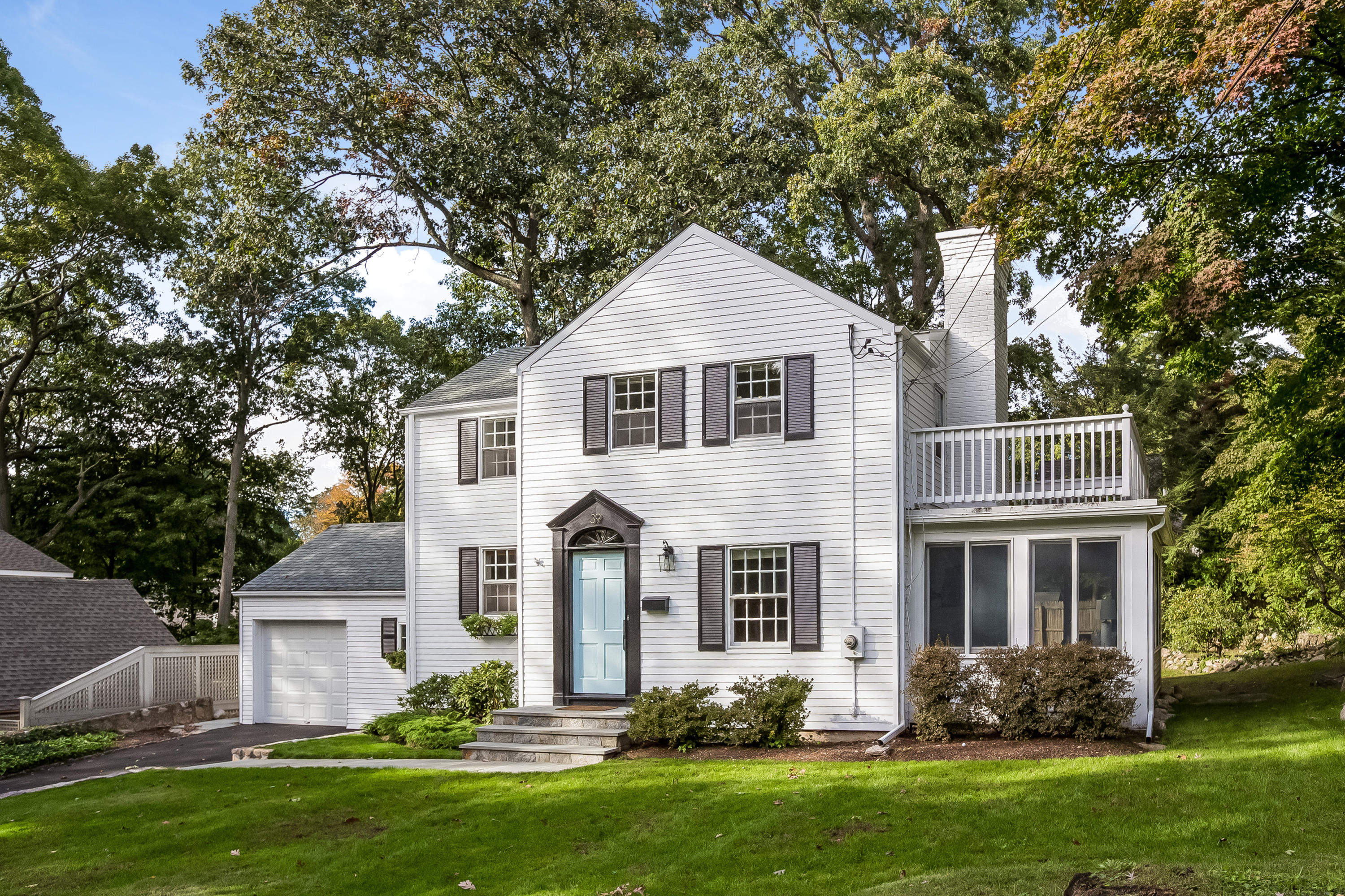 a front view of a house with a yard and green space