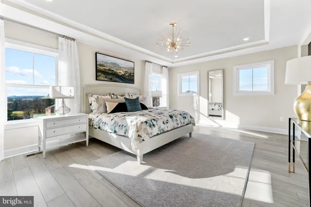 a bedroom with a large bed and a chandelier