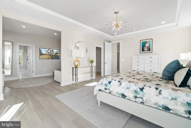 a bedroom with a large bed and a chandelier