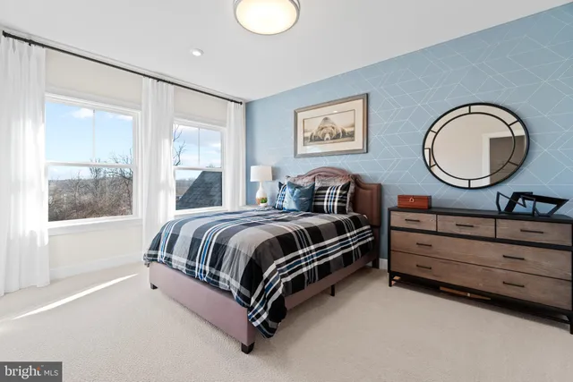 a spacious bedroom with a bed a window and painting on the wall